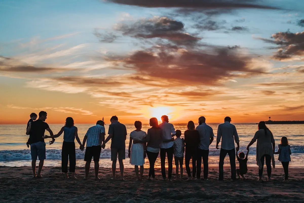 Large family group enjoying sunset together on beach